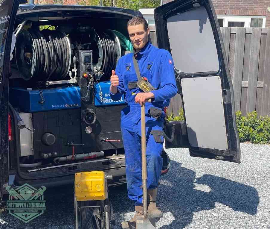 Een tevreden monteur met opgestoken duim naast de bestelbus, slim ingrijpen bespaart kosten bij een verstopte afvoer in Veenendaal