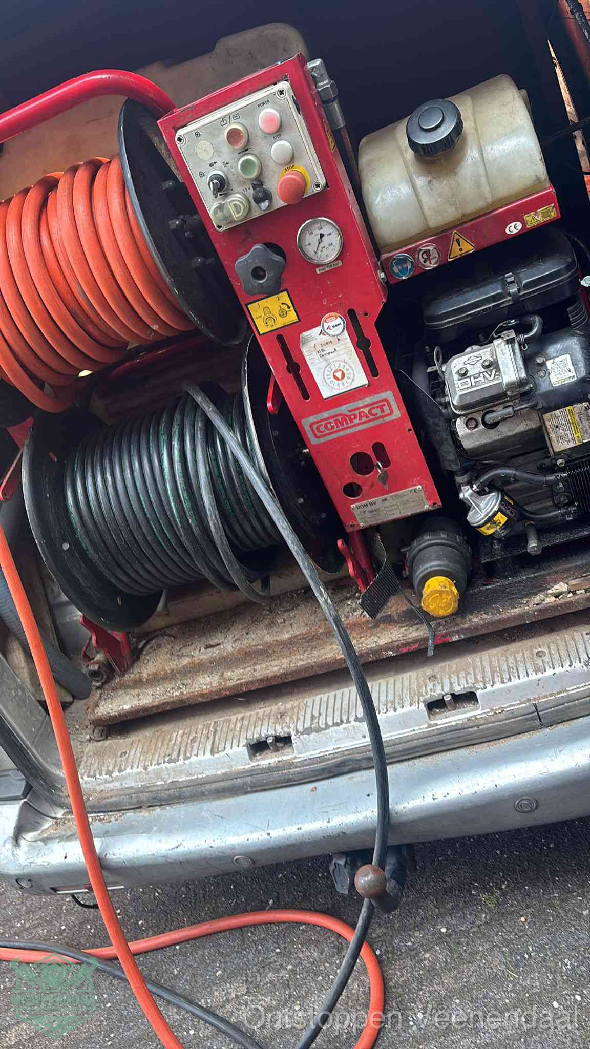 Een rood hogedruk-rioolreinigingstoestel in de laadbak van de bedrijfsbus, apparatuur voor een hardnekkige afvoerverstopping in Veenendaal
