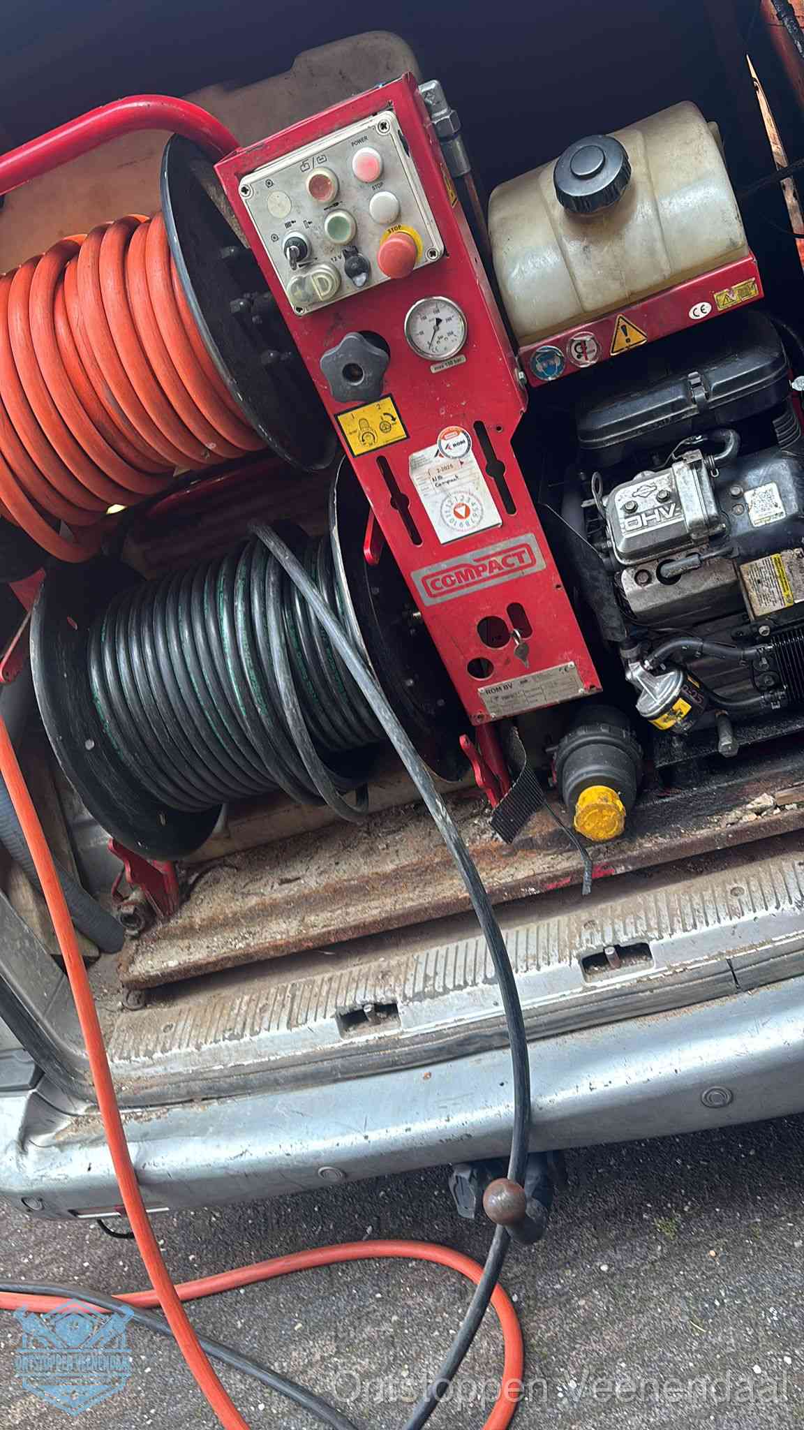 Een rood hogedruk-rioolreinigingstoestel met slangen in de laadbak van de bedrijfsbus, apparatuur voor een hardnekkige wc-verstopping in Veenendaal