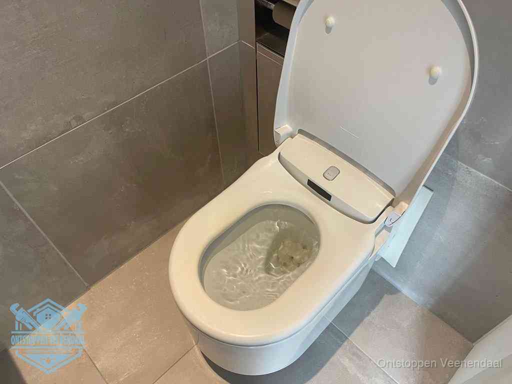 Een toiletpot vol troebel water met drijvend papier en restanten, de meest voorkomende oorzaak van een verstopte wc in Veenendaal